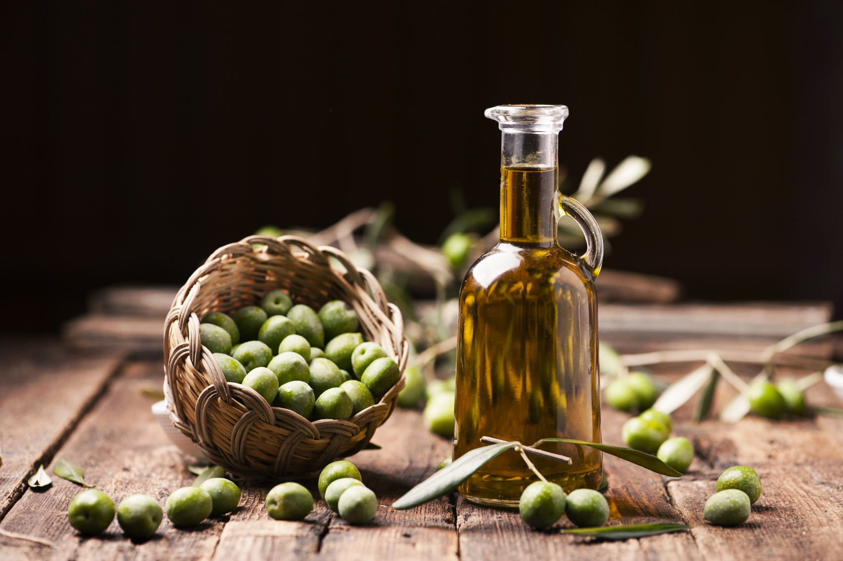 Olive oil and olive branch on the wooden table